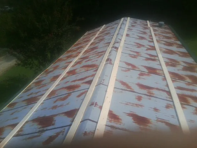 Rusted metal roof panels with new wood purlins before replacement — Storm Damage Roof Repair in Docena by Roofing Brothers