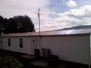New metal roof on a single wide mobile home with a TV antenna in Docena
