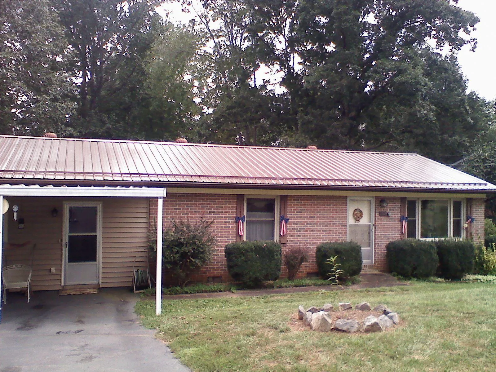 Bronze metal roof and carport on a brick ranch home — Roof Repair work by our crew in Docena